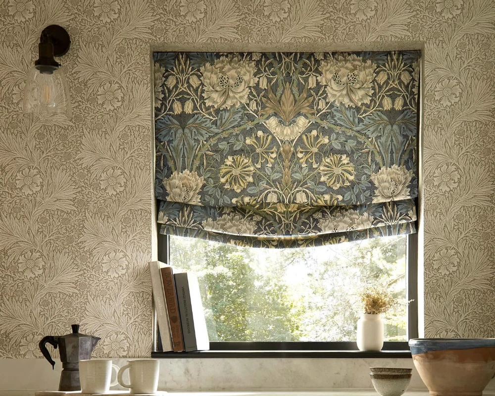 Floral Roman blind fitted above a kitchen window with coordinating botanical wallpaper.